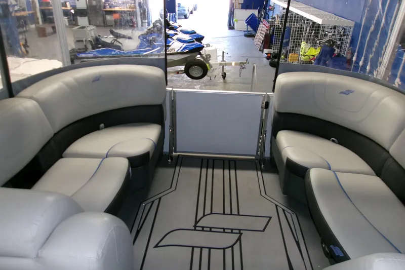 Slide: The Image of 2023 Starcraft SLS 3 Q DH pontoon boat interior with plush seating in a showroom. - 3