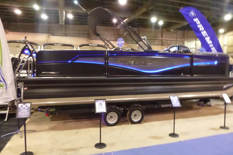 The Image of 2026 Premier 230 Intrigue RLO pontoon boat displayed indoors with blue LED lighting. - 1