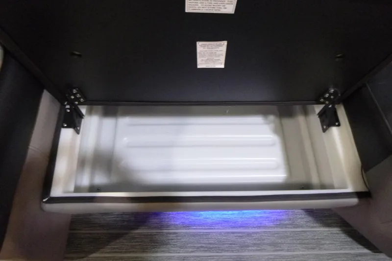 Slide: The Image of Open storage compartment in 2026 Premier 230 Intrigue RLO with blue LED lighting. - 10