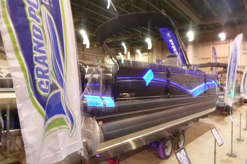 Slide: The Image of 2026 Premier 230 Intrigue RLO pontoon boat displayed at indoor boat show. - 2
