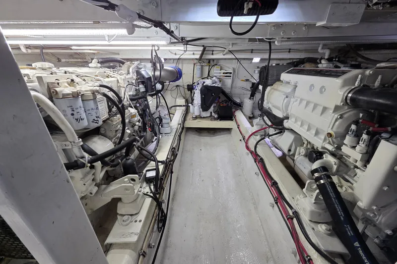 Slide: The Image of Engine room of a 2000 JM Custom 42 boat, featuring dual engines and wiring. - 14