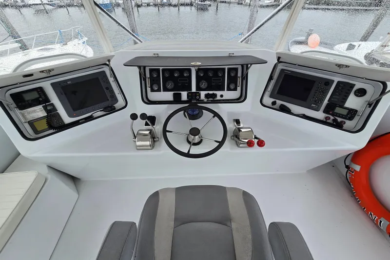 Slide: The Image of Helm of 2000 Custom 42 JM Sportfish boat with navigation equipment and steering wheel. - 15