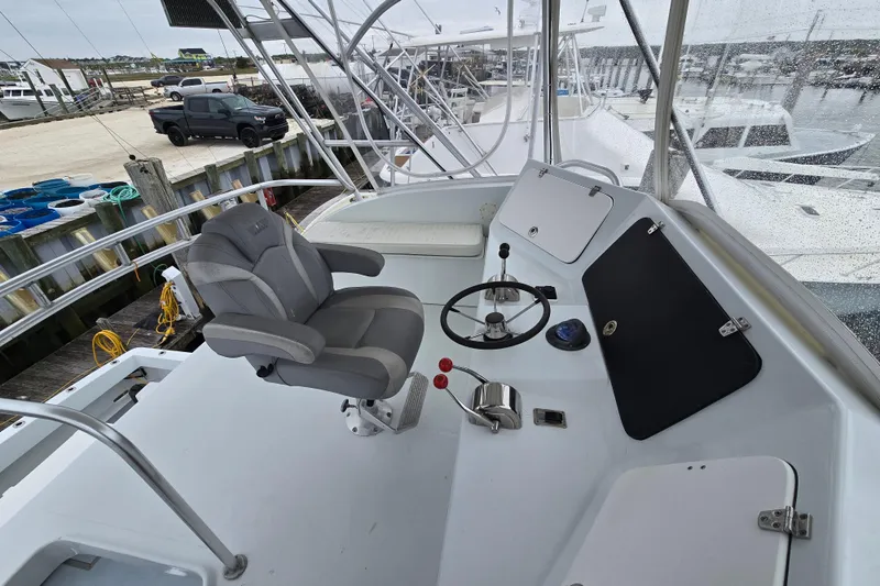 Slide: The Image of Helm of 2000 Custom 42 JM Sportfish boat with captain's chair and controls. - 18