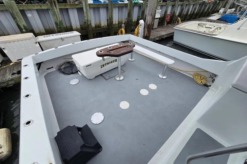 Slide: The Image of Custom 42 JM Sportfish Custom 2000 boat deck with fishing gear and seating at dock. - 20