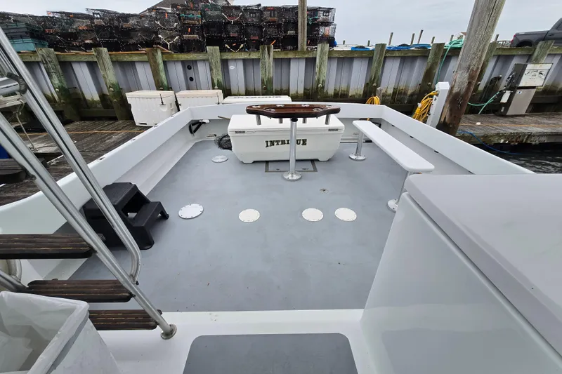 Slide: The Image of Open deck of 2000 Custom 42 JM Sportfish boat at dock, featuring seating and fishing equipment. - 22