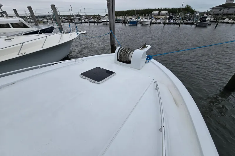 Slide: The Image of Bow of 2000 Custom 42 JM Sportfish boat docked at marina, featuring anchor winch. - 23