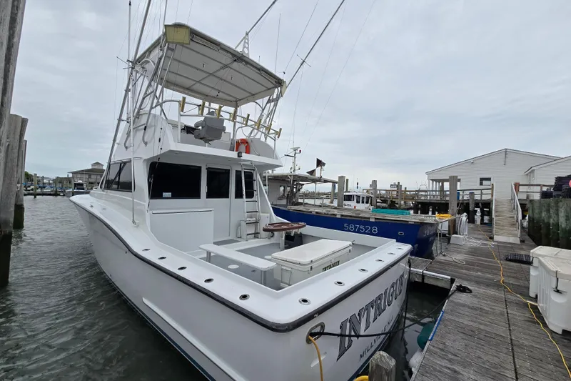 Slide: The Image of 2000 JM Custom 42 boat docked, featuring ladder and upper deck seating. - 27