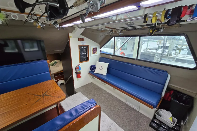 Slide: The Image of Interior of 2000 Custom 42 JM Sportfish boat with blue seating and fishing gear. - 28