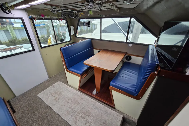 Slide: The Image of Interior of 2000 Custom 42 JM Sportfish boat with blue seating and wooden table. - 29