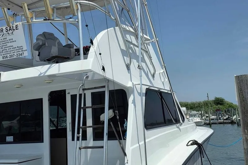 Slide: The Image of 2000 JM Custom 42 boat docked, featuring ladder and upper deck seating. - 3