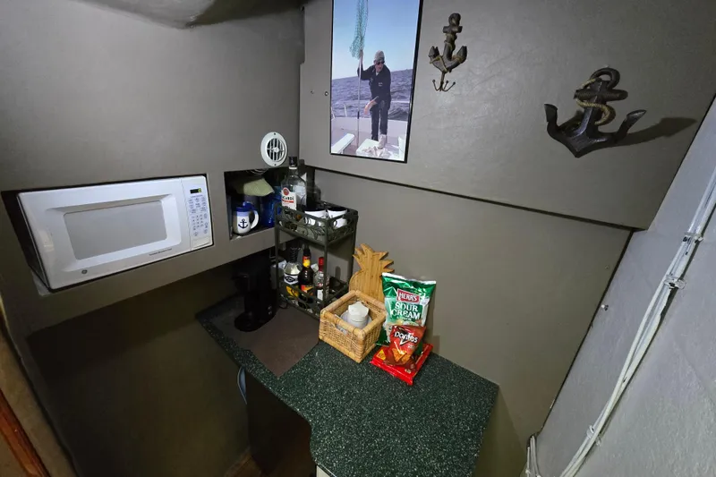 Slide: The Image of Compact kitchenette on 2000 Custom 42 JM Sportfish boat with microwave and snacks. - 32