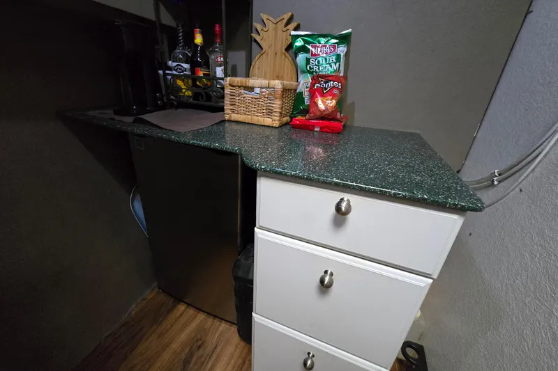 Slide: The Image of Small kitchenette with green countertop, snacks, and drinks on a 2000 Custom 42 JM Sportfish boat. - 33