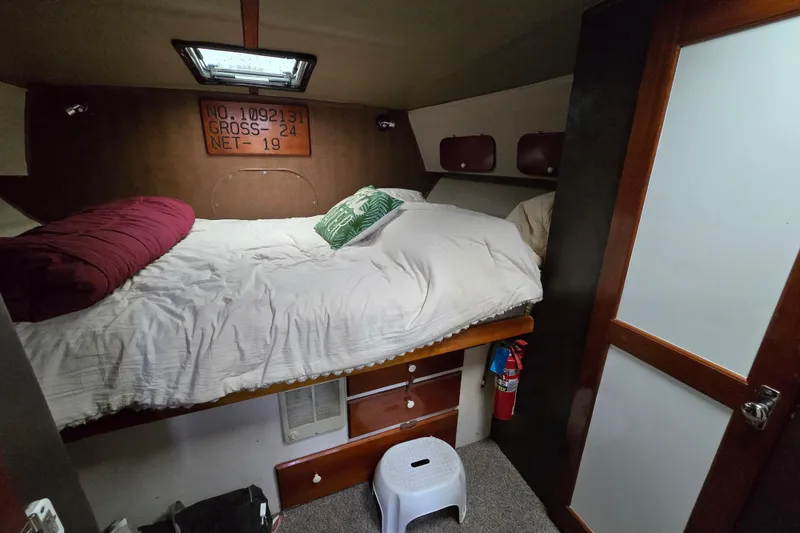 Slide: The Image of Cozy cabin interior of 2000 Custom 42 JM Sportfish boat with bed and storage. - 34
