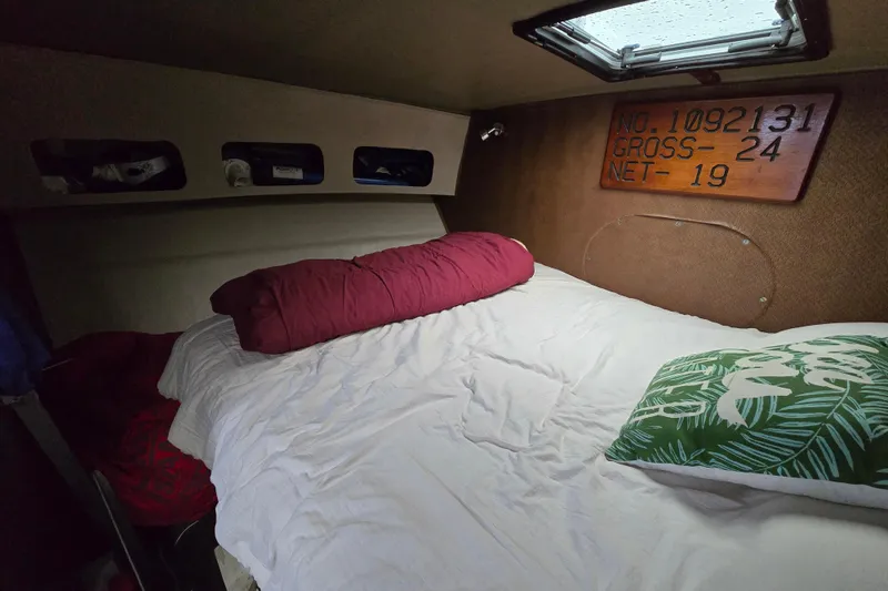 Slide: The Image of Cozy cabin interior of 2000 Custom 42 JM Sportfish boat with bed and decorative pillows. - 36