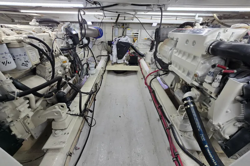 Slide: The Image of Engine room of a 2000 Custom 42 JM Sportfish boat, showcasing dual engines and mechanical components. - 38
