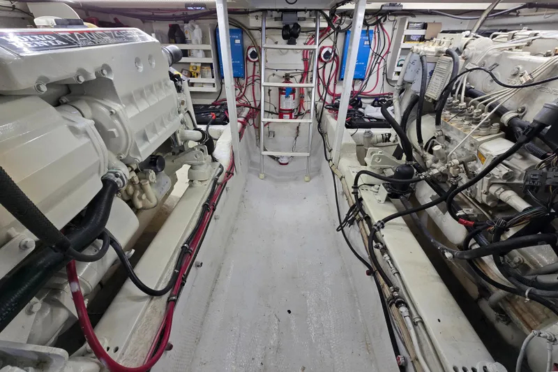 Slide: The Image of Engine room of 2000 Custom 42 JM Sportfish boat, featuring dual engines and wiring. - 44