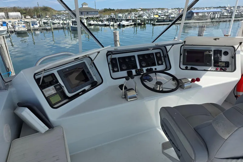 Slide: The Image of Helm of 2000 JM Custom 42 boat with navigation equipment and marina view. - 5