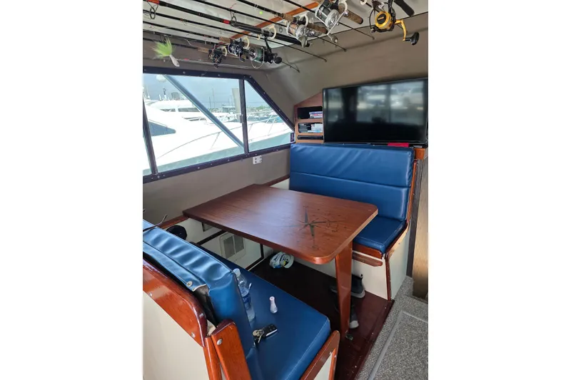 Slide: The Image of Interior of 2000 JM Custom 42 boat with blue seating and fishing rods. - 8