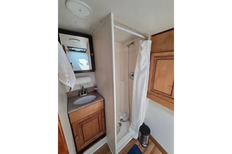 Slide: The Image of Compact bathroom in 2000 JM Custom 42, featuring shower, sink, and wooden cabinetry. - 9
