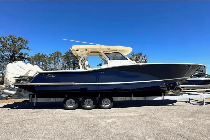 The Image of 2025 Scout 357 LXF boat on trailer, side view, clear blue sky background. - 0