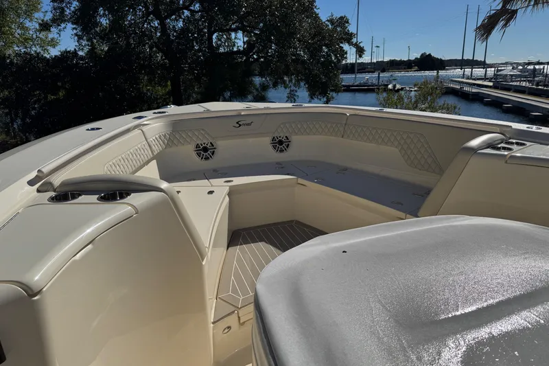 Slide: The Image of 2025 Scout 357 LXF boat interior with seating and cup holders, dockside view. - 10