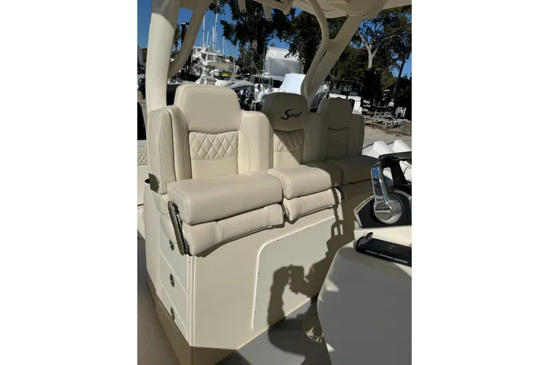 Slide: The Image of 2025 Scout 357 LXF boat with luxurious beige seating and steering console. - 11