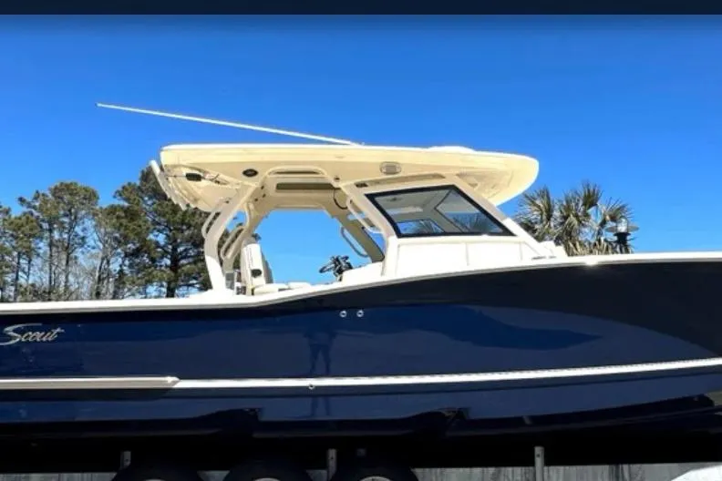 Slide: The Image of 2025 Scout 357 LXF boat with sleek design against a clear blue sky. - 2