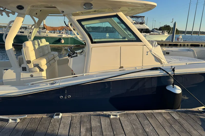 Slide: The Image of 2025 Scout 357 LXF boat docked at marina, showcasing sleek design and luxury seating. - 3