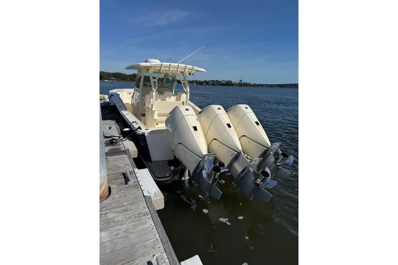 Slide: The Image of 2025 Scout 357 LXF boat docked with triple outboard engines. - 7