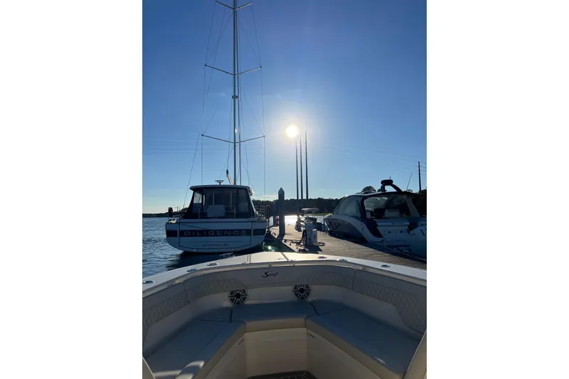 Slide: The Image of 2025 Scout 357 LXF boat docked at marina under clear blue sky. - 9