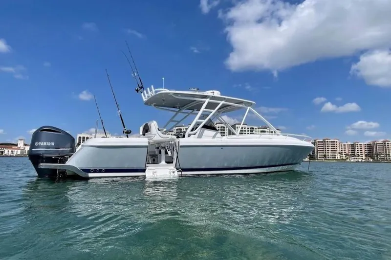 The Image of 2014 Intrepid 327 Cuddy boat on water, clear sky, Yamaha engine visible. - 0