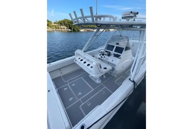 Slide: The Image of 2014 Intrepid 327 Cuddy boat with modern helm, docked on calm water. - 10