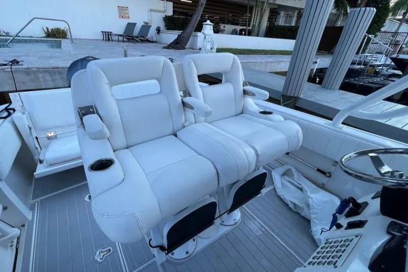 Slide: The Image of 2014 Intrepid 327 Cuddy boat with white cushioned seating and modern design. - 11