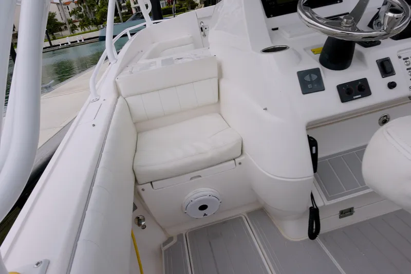 Slide: The Image of 2014 Intrepid 327 Cuddy boat interior with white seating and steering console. - 12
