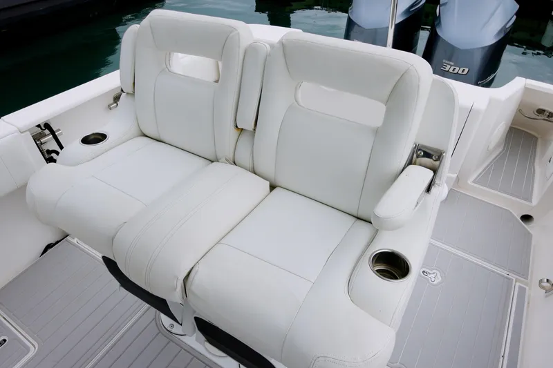 Slide: The Image of White leather seating on 2014 Intrepid 327 Cuddy boat with cup holders. - 13
