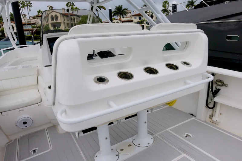 Slide: The Image of 2014 Intrepid 327 Cuddy boat interior with seating and rod holders. - 14