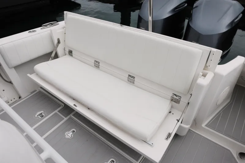 Slide: The Image of 2014 Intrepid 327 Cuddy boat with white cushioned seating and dual outboard motors. - 15