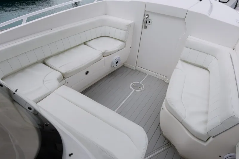 Slide: The Image of 2014 Intrepid 327 Cuddy boat interior with white cushioned seating. - 17