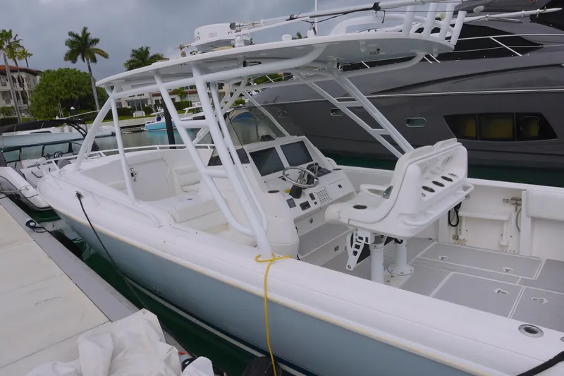 Slide: The Image of 2014 Intrepid 327 Cuddy boat docked, featuring a sleek white design and modern cockpit. - 2