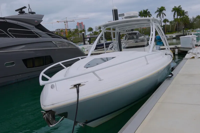 Slide: The Image of 2014 Intrepid 327 Cuddy boat docked at marina with palm trees in background. - 3