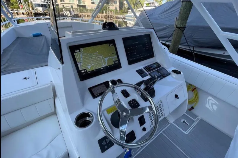 Slide: The Image of 2014 Intrepid 327 Cuddy boat dashboard with navigation screens and steering wheel. - 6
