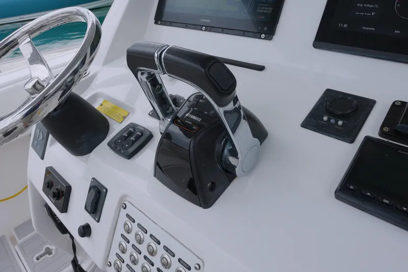 Slide: The Image of Control panel of a 2014 Intrepid 327 Cuddy boat with steering wheel and throttle. - 9