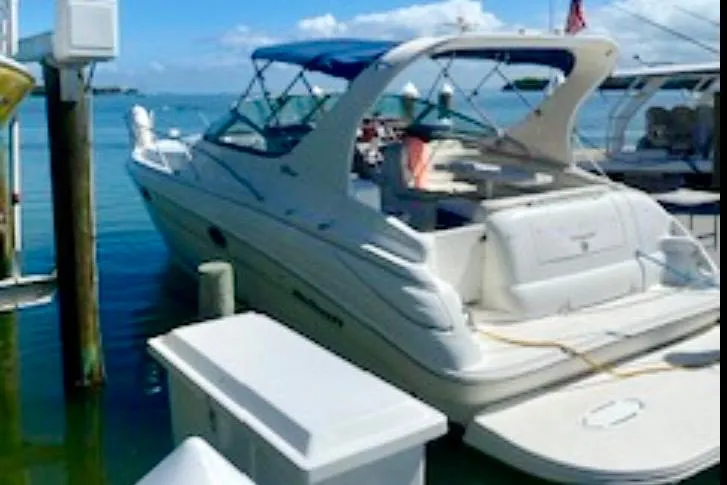 The Image of 2002 Wellcraft 3300 Martinique yacht docked at marina under clear blue sky. - 0