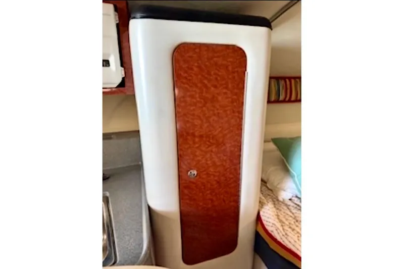 Slide: The Image of 2002 Wellcraft 3300 Martinique cabin interior with wood paneling and cozy bedding. - 17