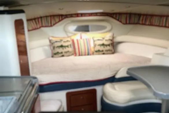 Slide: The Image of 2002 Wellcraft 3300 Martinique cabin interior with cozy bed and colorful pillows. - 6