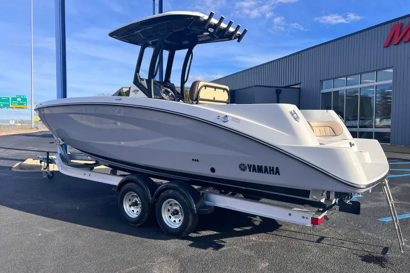 Slide: The Image of 2026 Yamaha 255 FSH Sport E boat on trailer outside building. - 2