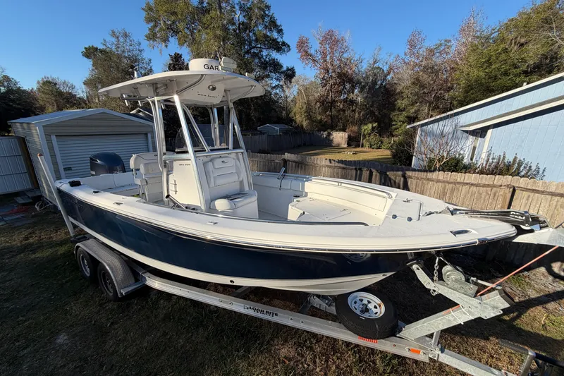 Slide: The Image of 2015 Sea Hunt Ultra 225 boat on trailer in a backyard setting. - 14