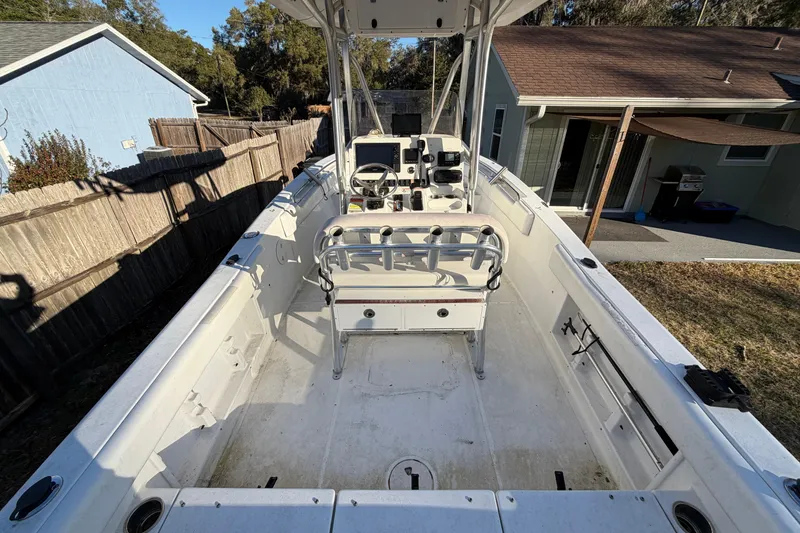 Slide: The Image of 2015 Sea Hunt Ultra 225 boat interior with console and seating, parked in a residential yard. - 18