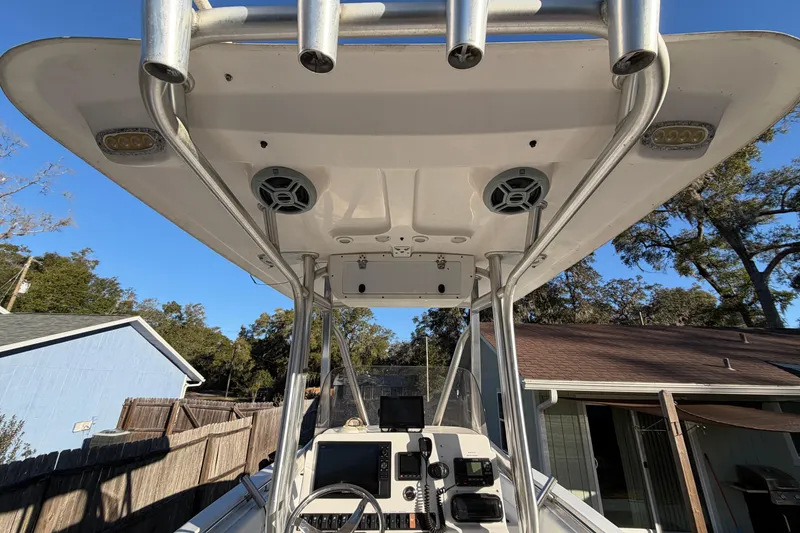 Slide: The Image of 2015 Sea Hunt Ultra 225 boat console with T-top and electronics, parked outdoors. - 20