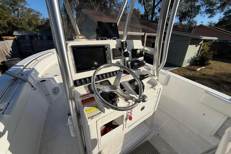 Slide: The Image of 2015 Sea Hunt Ultra 225 boat cockpit with steering wheel and navigation equipment. - 25